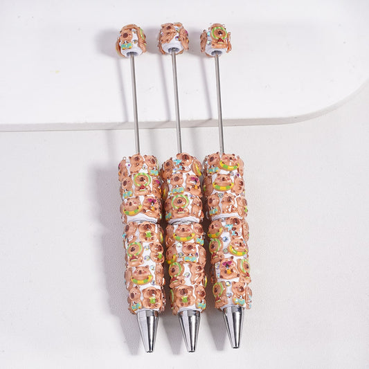 Three pens with decorative tops on a white background

