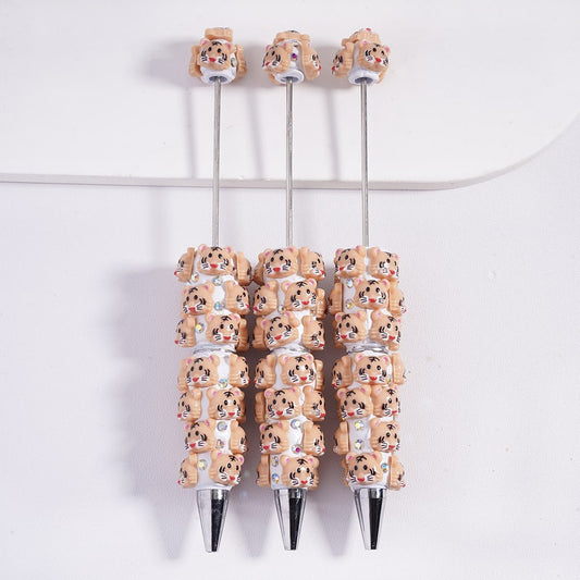 Three pens with decorative animal heads on a white background