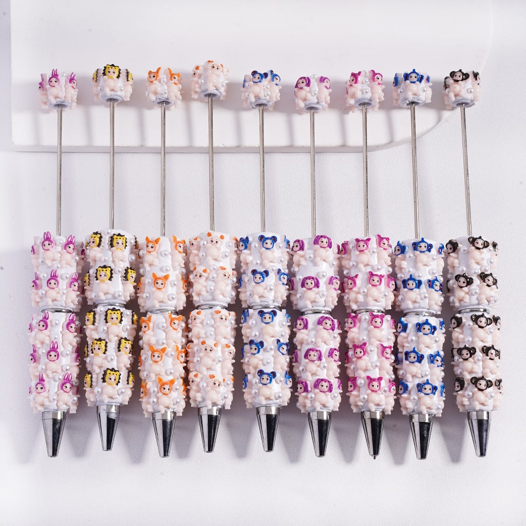 Row of pens with decorative tops on a white background