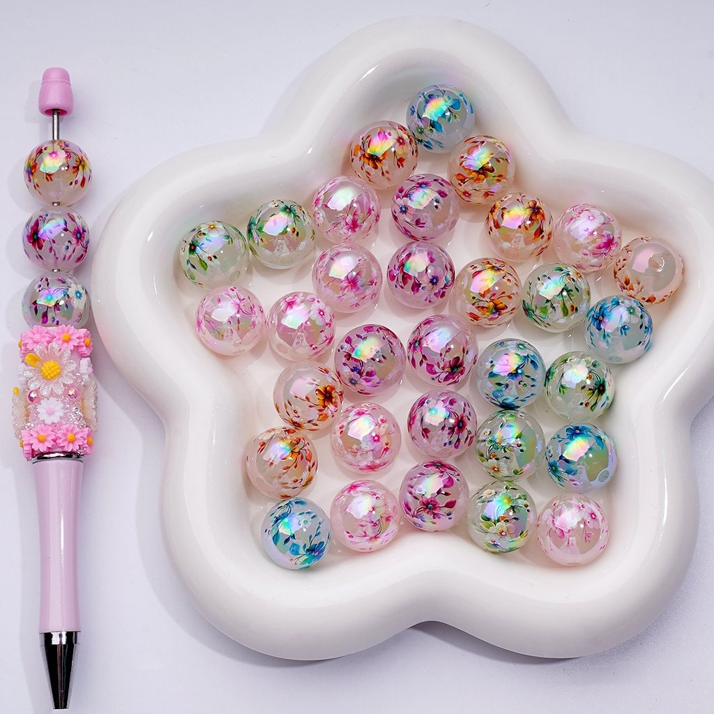 Colorful beads with a decorative pen on a heart-shaped white dish

