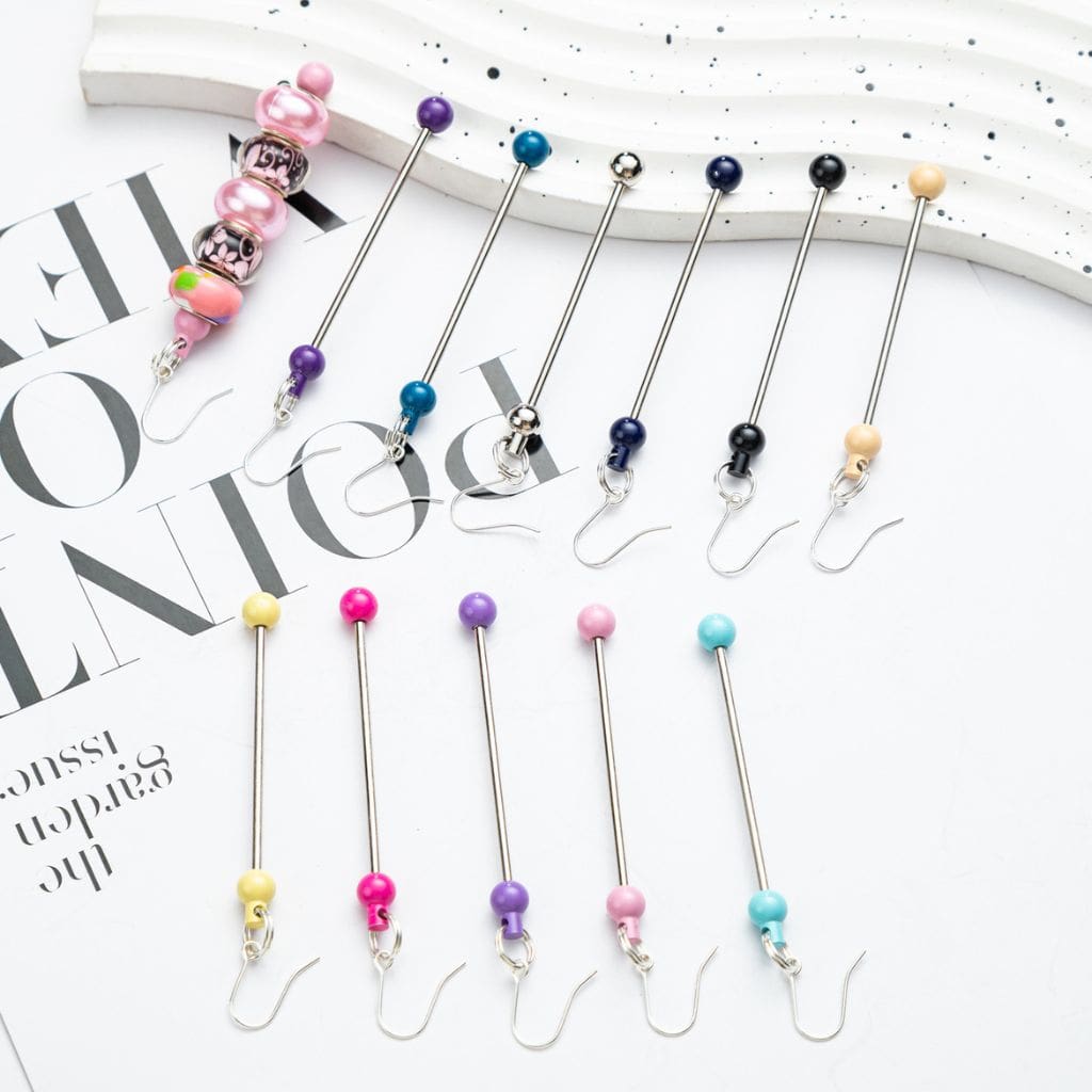 A collection of beaded earrings displayed on a surface, with a variety of colors including pink, blue, green, yellow, and purple represented in the beads.

