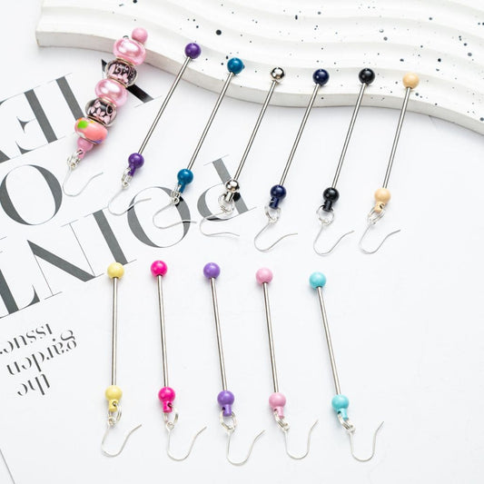 A collection of beaded earrings displayed on a surface, with a variety of colors including pink, blue, green, yellow, and purple represented in the beads.

