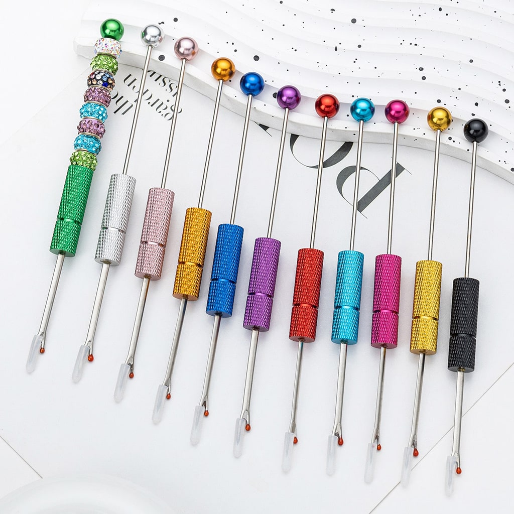 Set of colorful sewing needles with various colored handles on a white background

