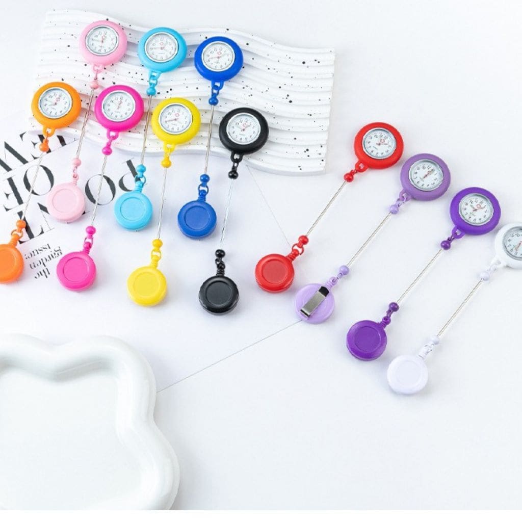 A collection of retractable badge holders with integrated mini pocket clocks in various colors, each featuring a beaded chain and a keychain bar.

