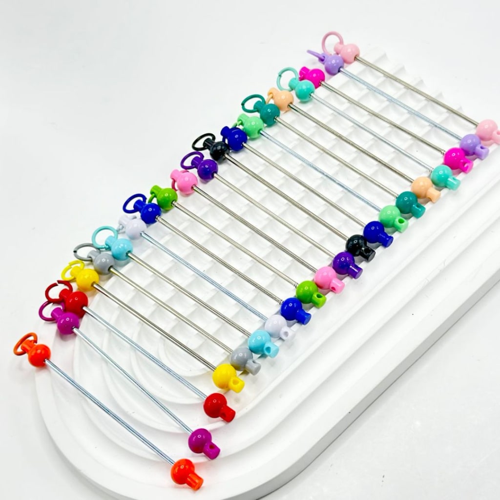 An assortment of colorful beadable bars for keychains and accessories, displayed on a white surface.

