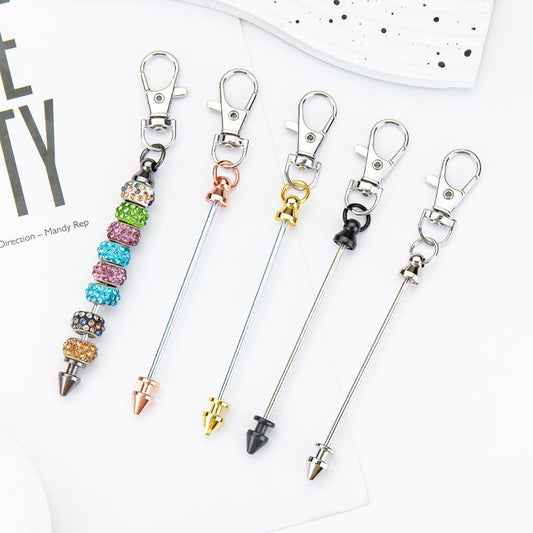 A selection of metal bullet head keychains with beadable bars and lobster clasp hooks in various colors.

