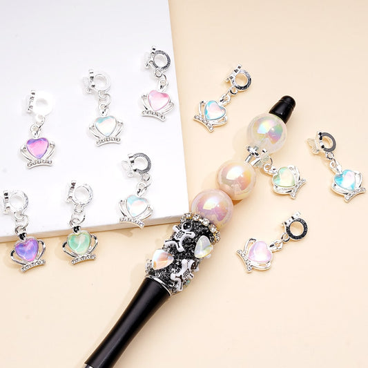 Decorative pen with gemstone charms on a light background


