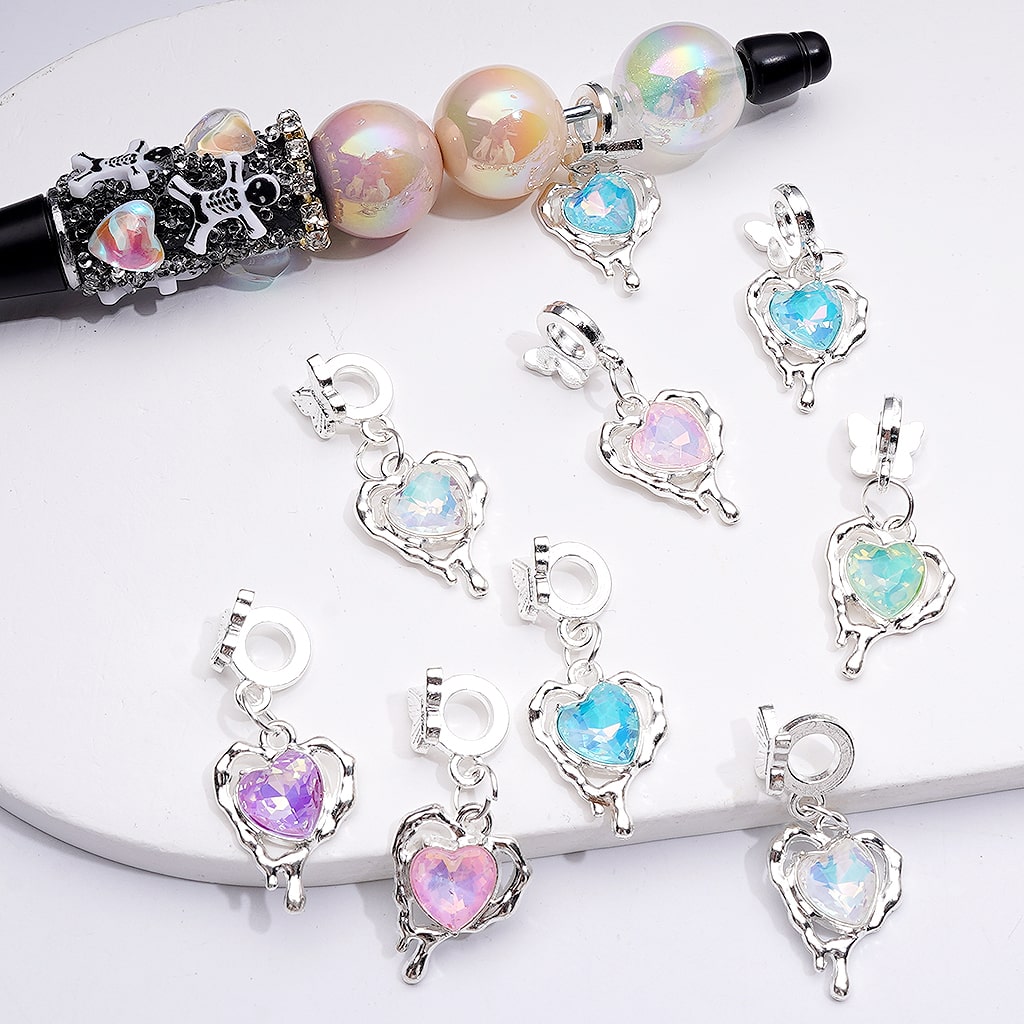 Heart-shaped charms with colorful heart-shaped stones on a white surface

