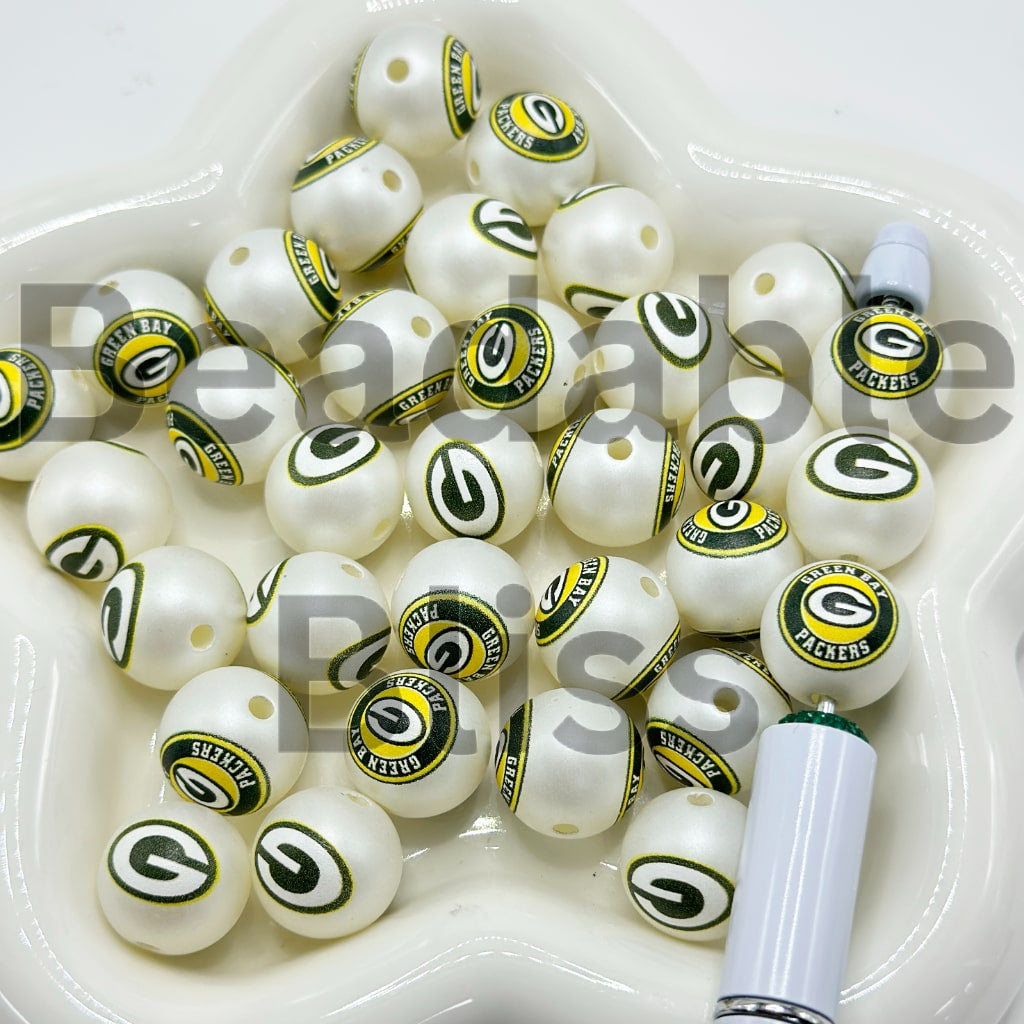 White beads with Green Bay Packers logos in a white container.

