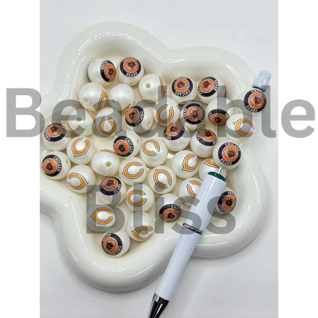 Set of decorative beads with a pen on a heart-shaped white dish

