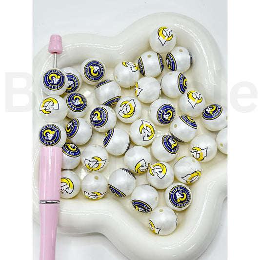White beads with logos in a heart-shaped container with a pink pen

