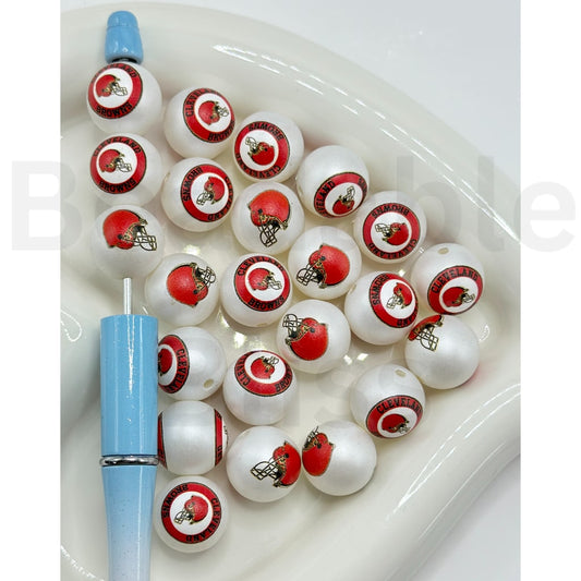 Set of white beads with red and black designs on a white surface

