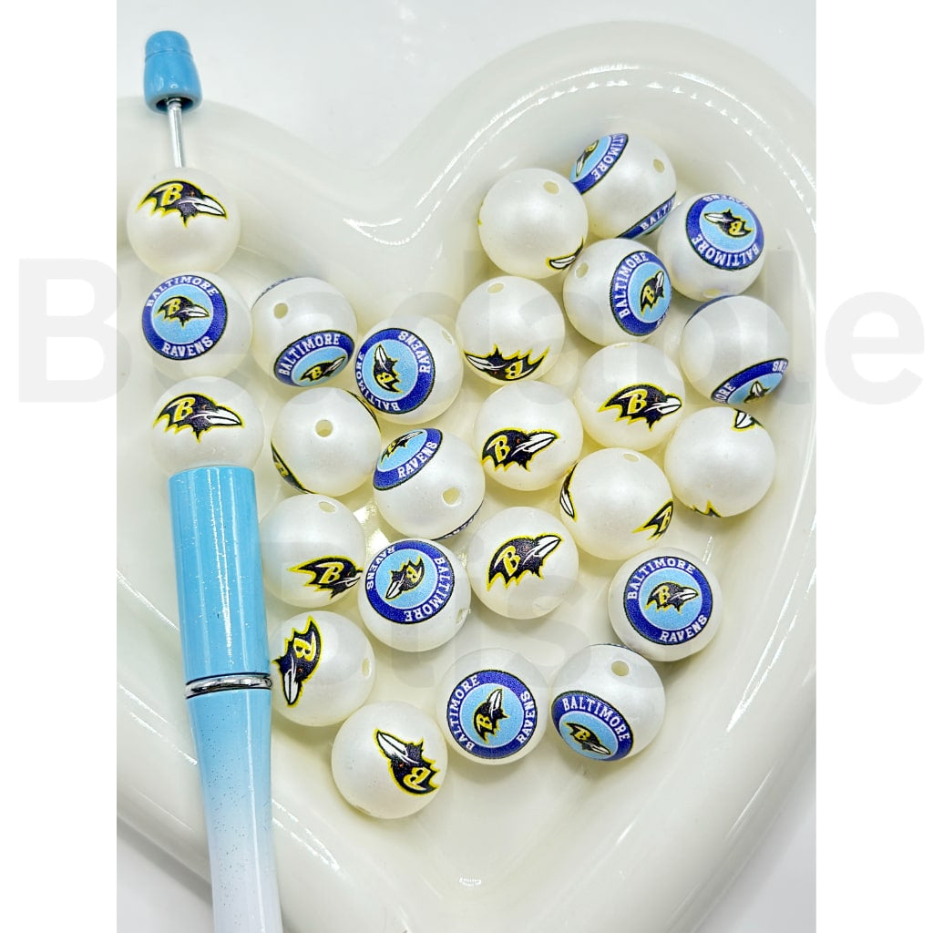 White fishing lures with logos on a white tray, accompanied by a blue tool.

