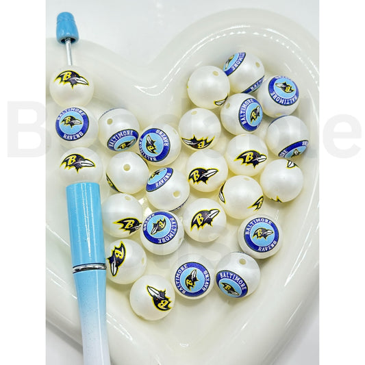 White fishing lures with logos on a white tray, accompanied by a blue tool.

