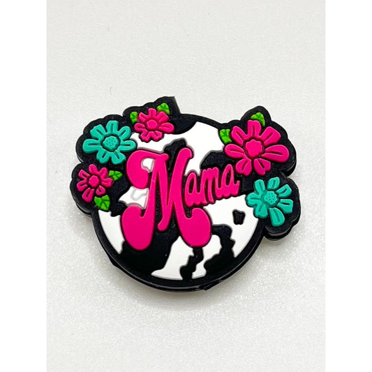 A silicone bead with a black and white cow print design, pink flowers, and the text 'Mama' in pink and black.

