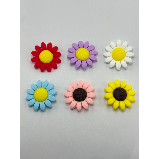 A collection of silicone beads in the shape of flowers, displayed in various colors such as red, purple, yellow, white, blue, and pink.

