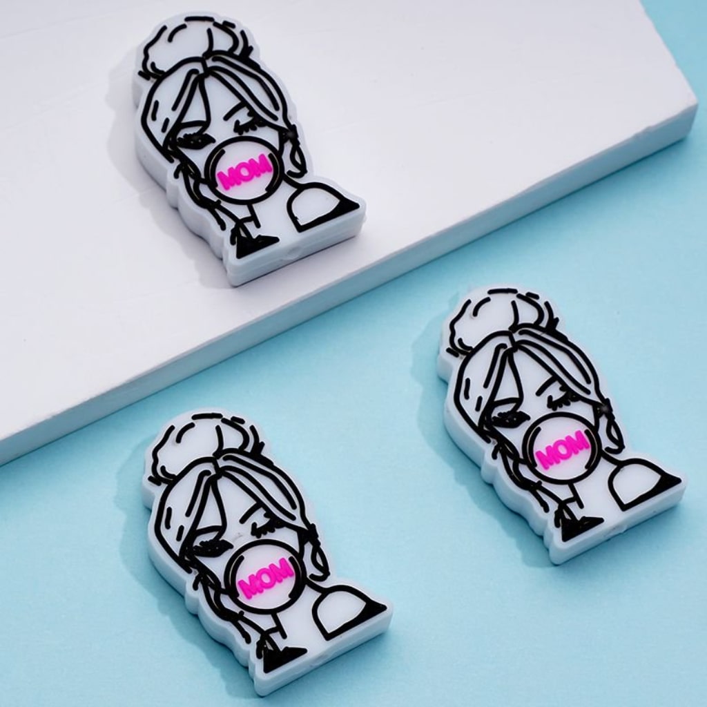 Three silicone beads with a graphic of a woman's face, designed for crafting purposes.

