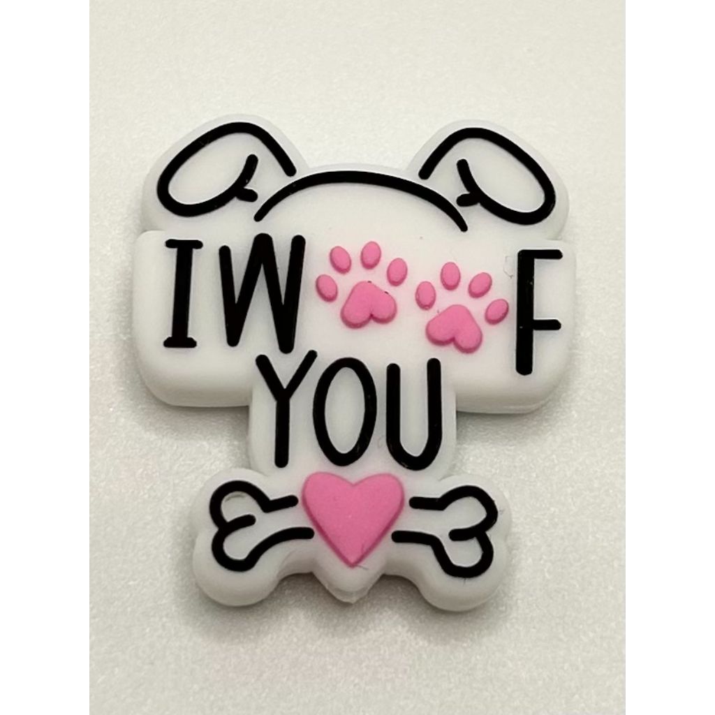 A silicone focal bead featuring a dog paw design with the phrase 'I Woof You' written on it. The background is white, with black lettering and pink accents.

