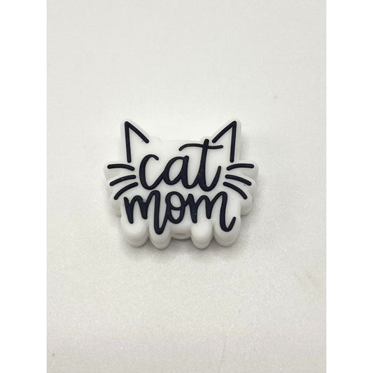 A silicone bead with the text 'cat mom' and a simple graphic of a cat's face.

