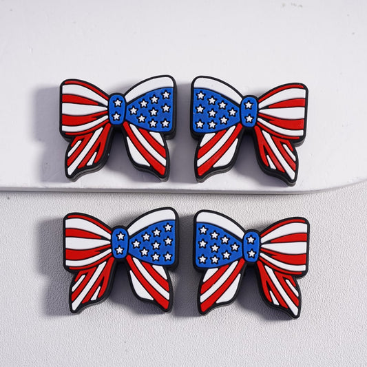 Four American flag-themed bow-shaped pins on a white background

