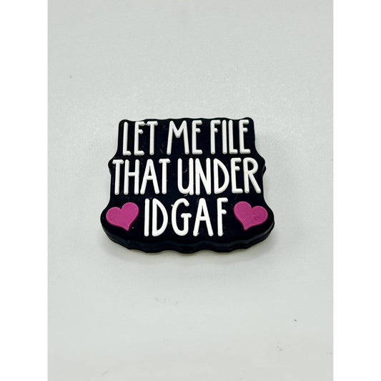 A black silicone focal bead with white text and pink accents that reads 'LET ME FILE THAT UNDER IDGAF'.

