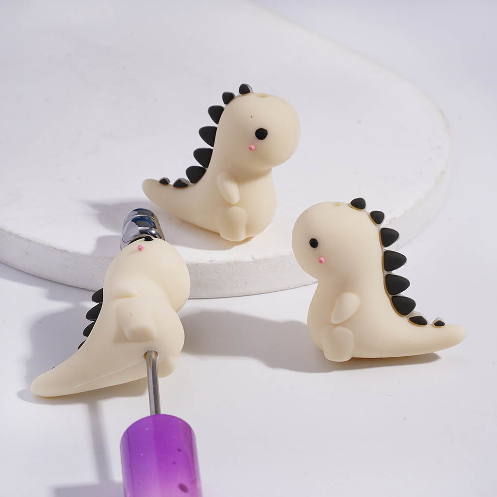 Three dinosaur-shaped cable protectors on a white background

