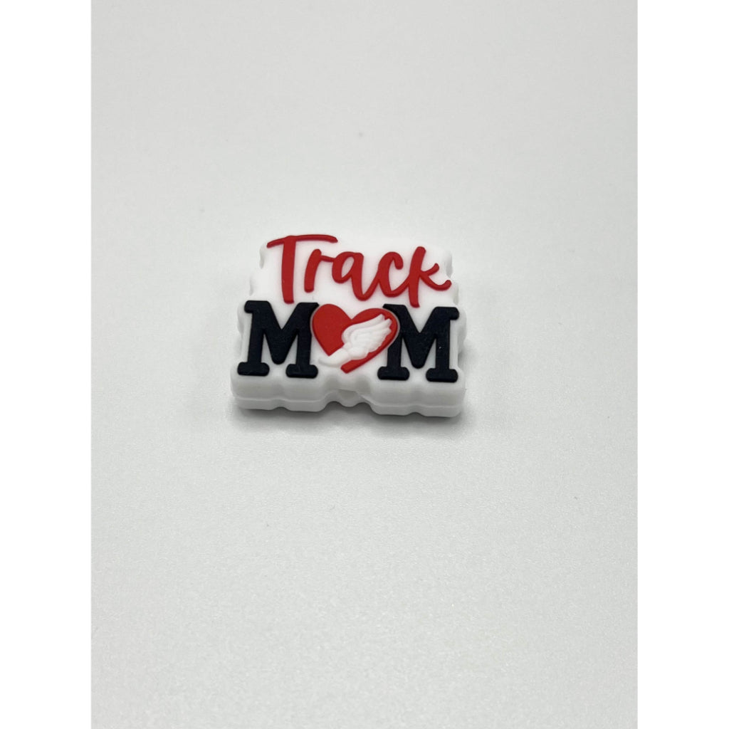 A silicone bead with the text 'Track Mom' and a heart symbol on it, primarily in white color with red and black text.


