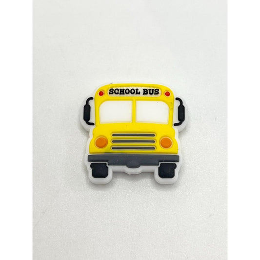 A yellow silicone bead in the shape of a school bus.

