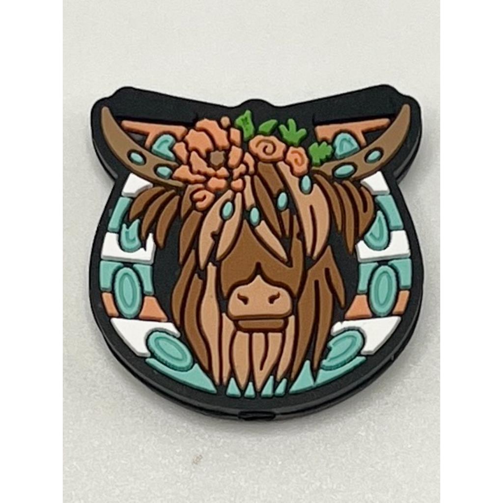 A silicone bead featuring a floral pattern with a cow's head in the center, predominantly brown in color.

