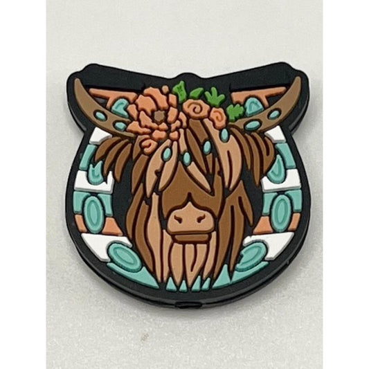 A silicone bead featuring a floral pattern with a cow's head in the center, predominantly brown in color.

