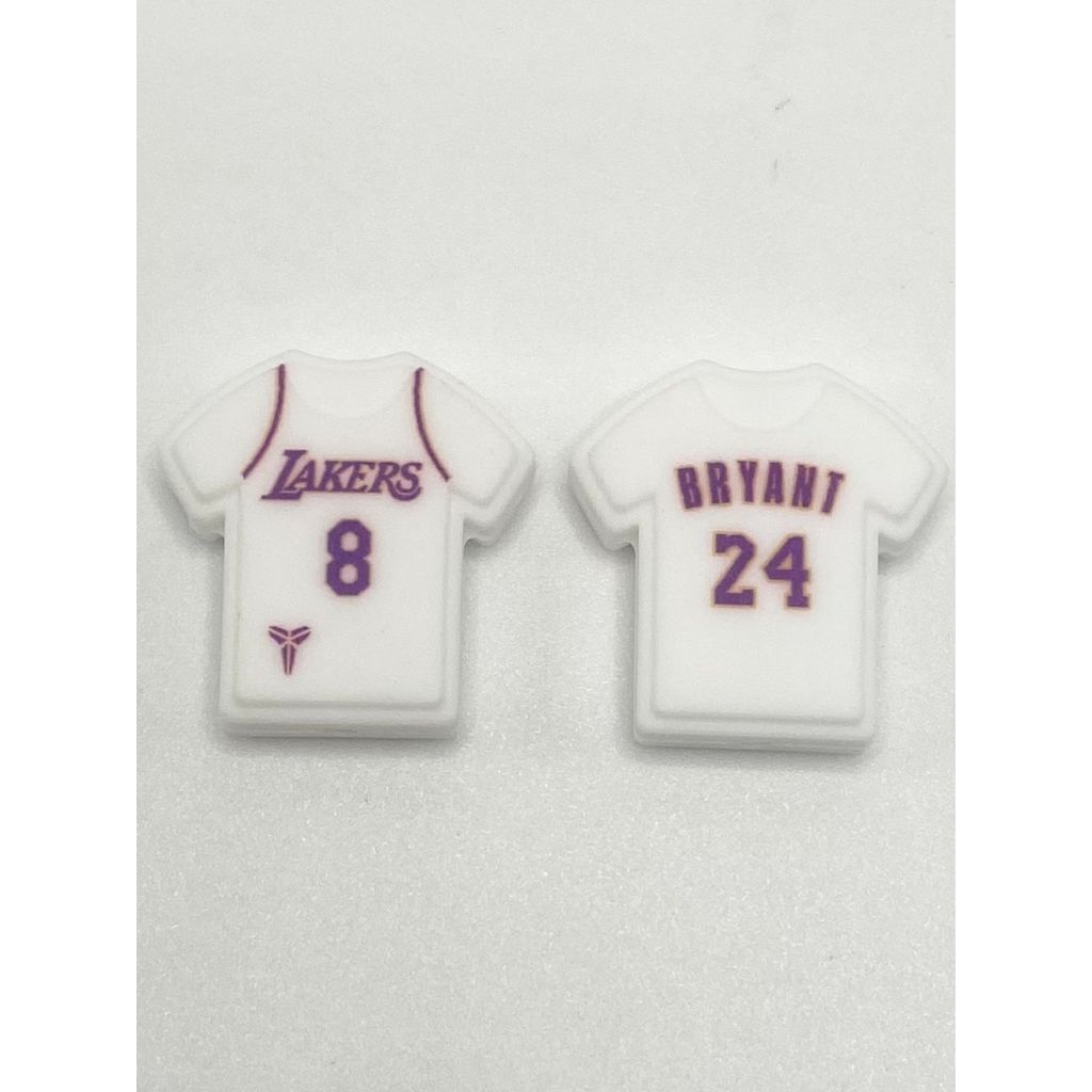 Two silicone beads designed to look like white basketball jerseys with the text 'Lakers 8' and 'Bryant 24' on them.

