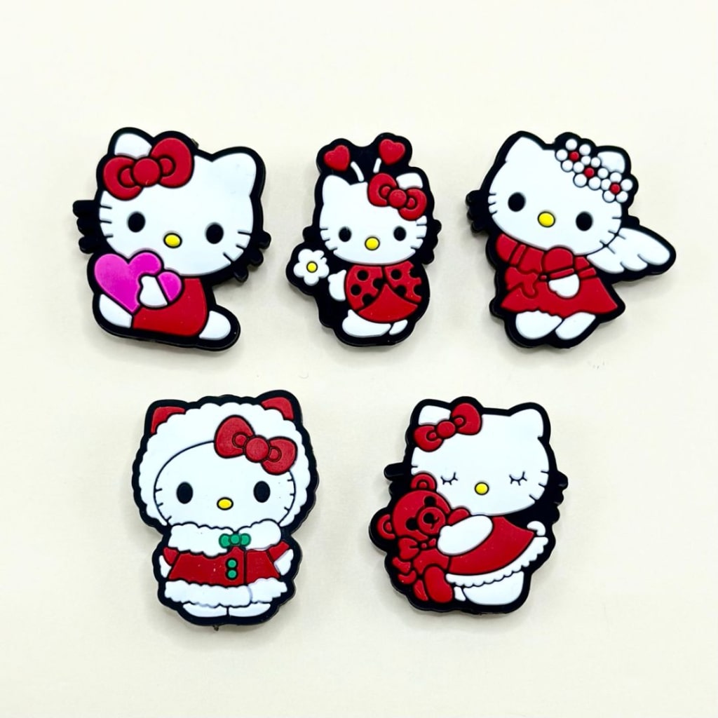 A collection of silicone beads in the shape of Hello Kitty dressed in various Christmas-themed outfits, such as with a red bow, or Santa hat.


