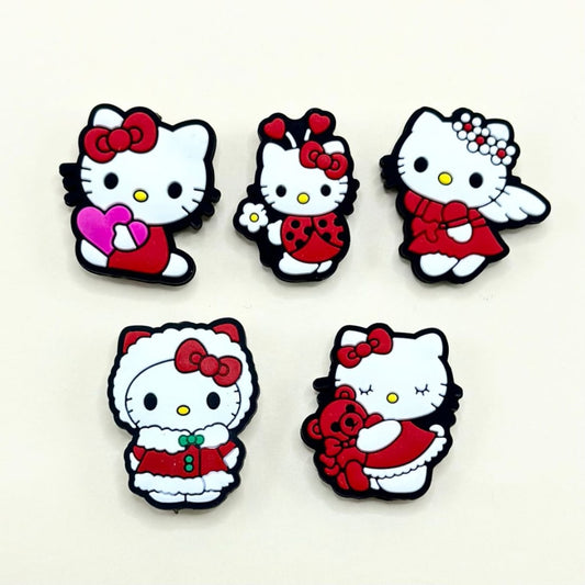 A collection of silicone beads in the shape of Hello Kitty dressed in various Christmas-themed outfits, such as with a red bow, or Santa hat.

