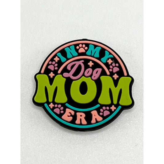 A silicone focal bead with the text 'In My Dog Mom Ear' and decorative elements such as paw prints and flowers.

