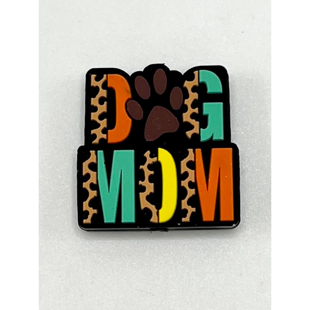 A silicone focal bead with a brown leopard print background and the text 'DOG MOM' in multicolored letters.


