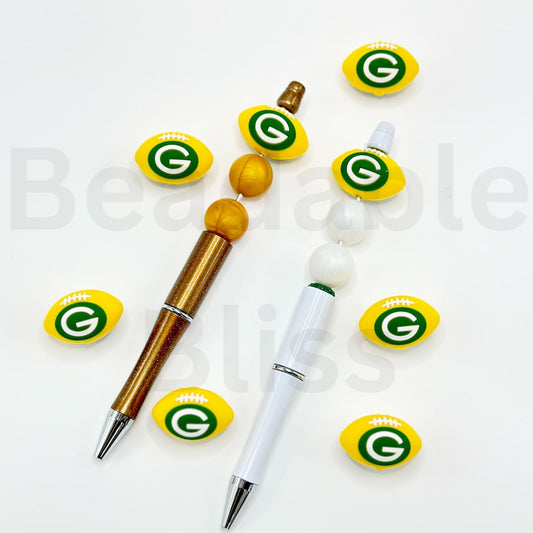 Two pens, one gold and one white, with green and yellow accents on a white background.

