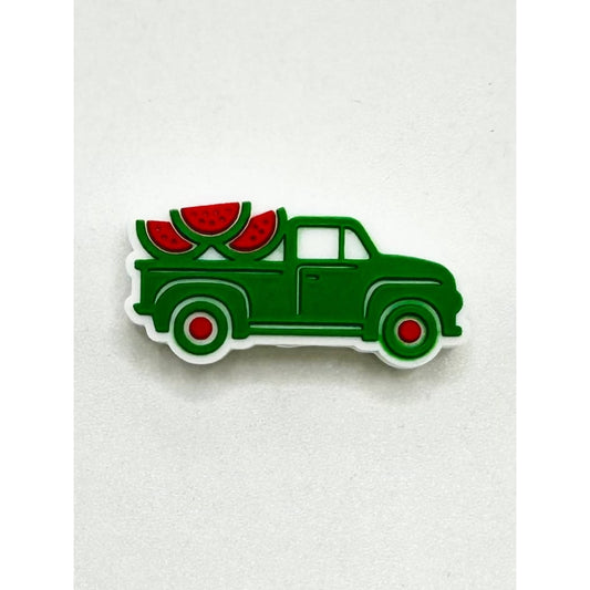 A silicone bead in the shape of a green pickup car with watermelon slices on the back

