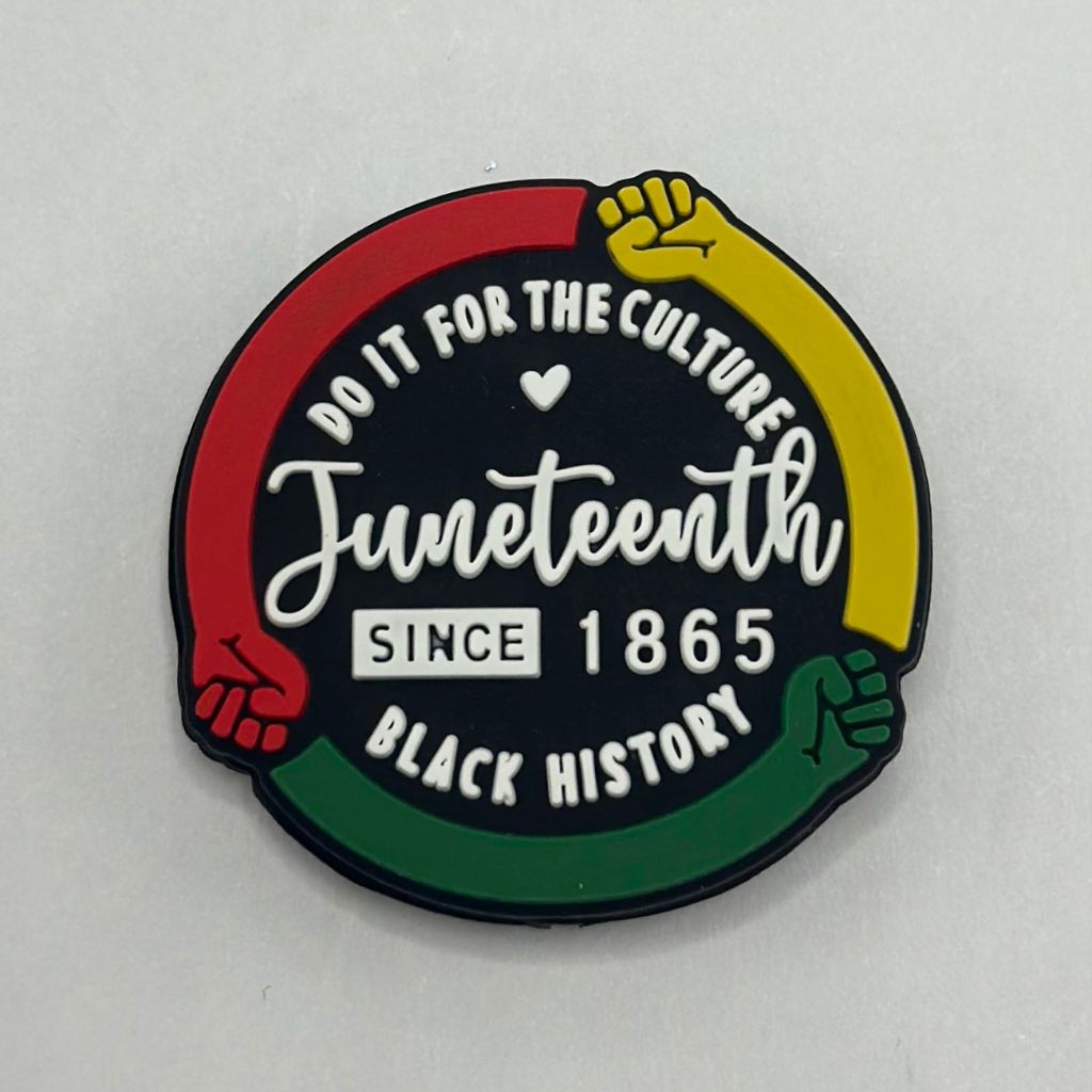 A silicone bead with the text 'JUNETEENTH SINCE 1865' and the colors of the Pan-African flag, along with raised fists symbolizing the Black Power movement.

