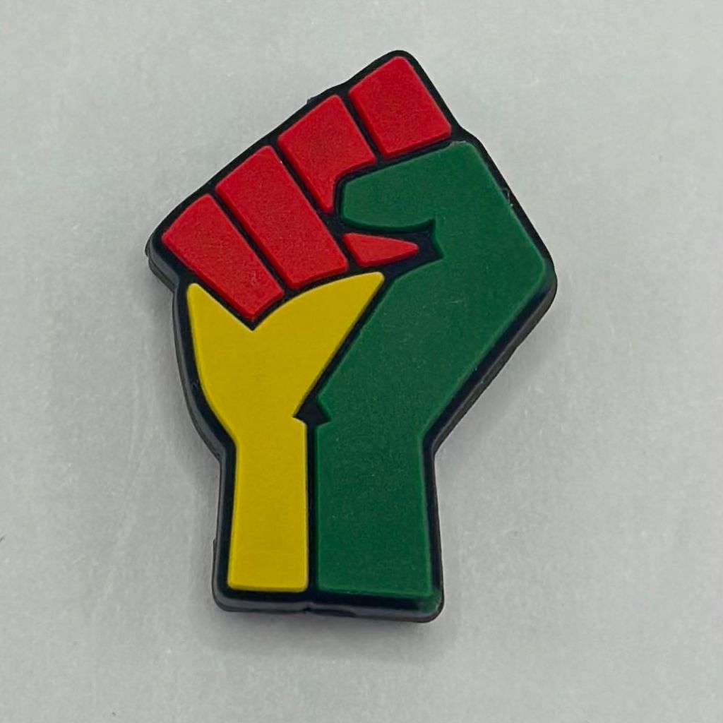 A silicone bead in the shape of a fist, with red, yellow, and green colors representing the Pan-African flag.

