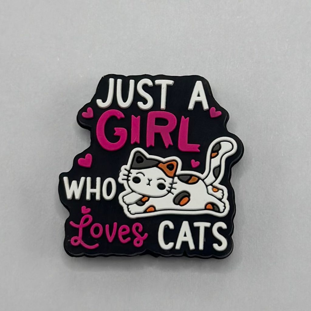 A silicone bead with an illustration of a cat and the text 'JUST A GIRL WHO LOVES CATS' in pink and white colors on a black background.


