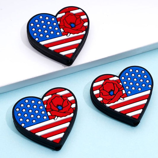 Silicone beads in the shape of hearts with the American flag design and red flowers.

