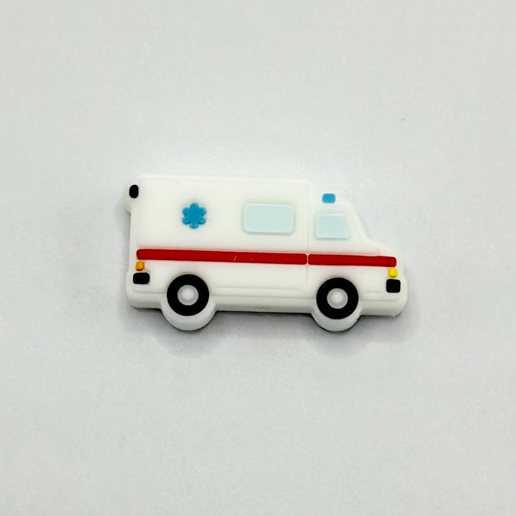 A white silicone bead in the shape of an ambulance with red and blue accents and a medical cross design on the side.

