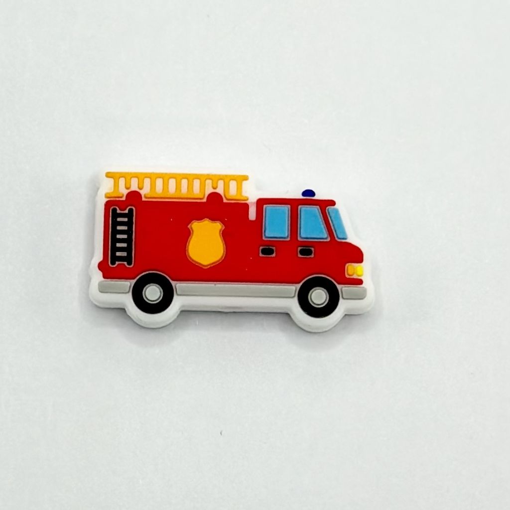 A silicone bead in the shape of a red and yellow fire truck with a yellow medal.

