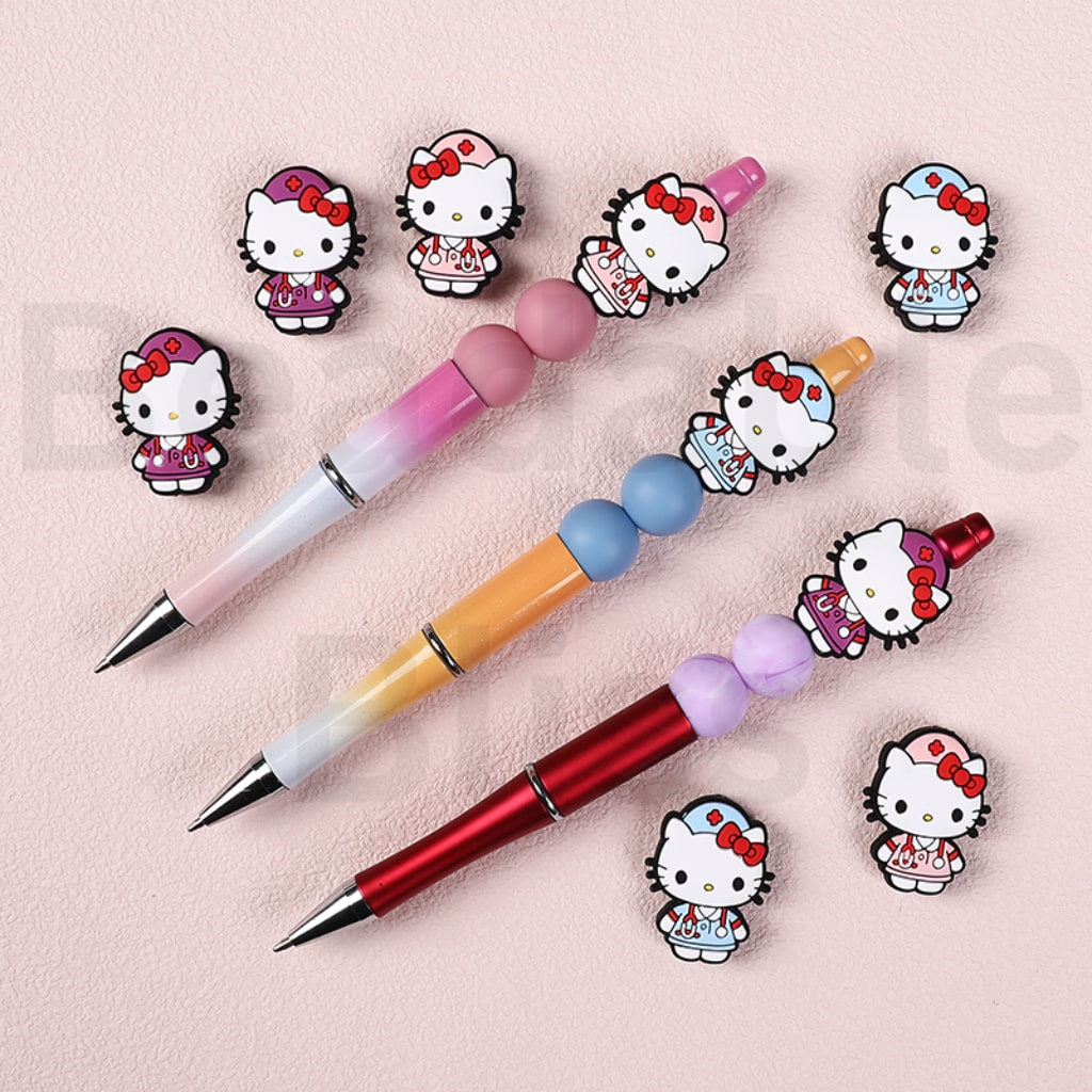Three colorful pens with Hello Kitty character pen toppers on a pink background

