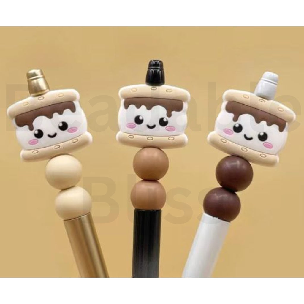 Three cute cake-shaped pens with smiling faces on a beige background

