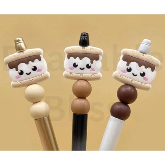 Three cute cake-shaped pens with smiling faces on a beige background

