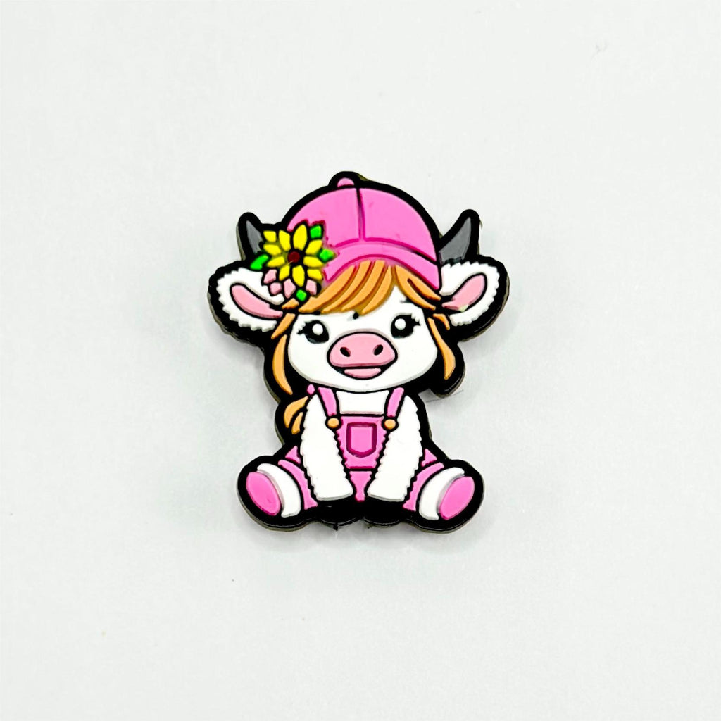 A silicone bead featuring a cartoon-style calf with a yellow flower on its head and a pink hat.

