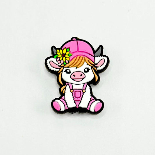 A silicone bead featuring a cartoon-style calf with a yellow flower on its head and a pink hat.

