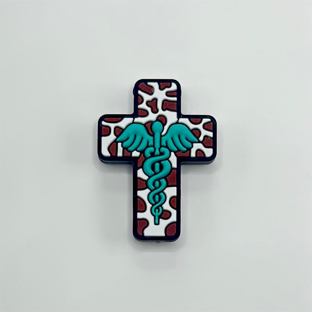 An assortment of silicone beads in the shape of a cross, featuring a cow print background with different colored wings.

