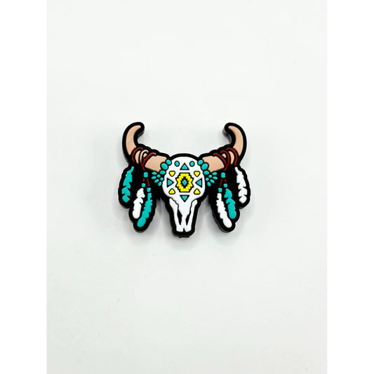 Decorative bull skull with teal feathers and yellow center on a white background

